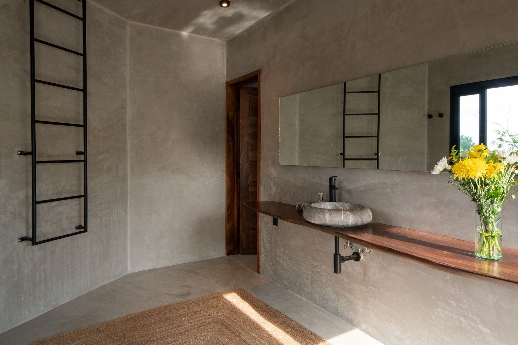 Stone basin on a live-edge wood counter in the garden-suite bathroom