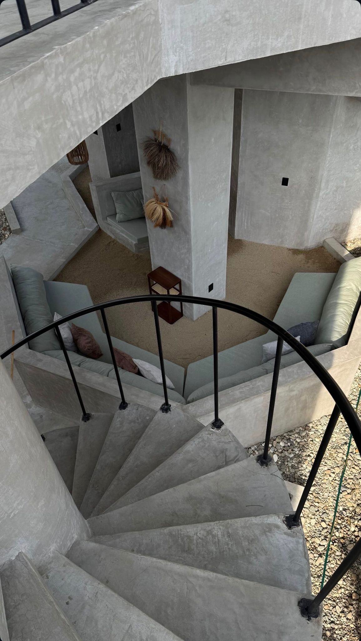 Concrete spiral staircase seen from above over the lounge