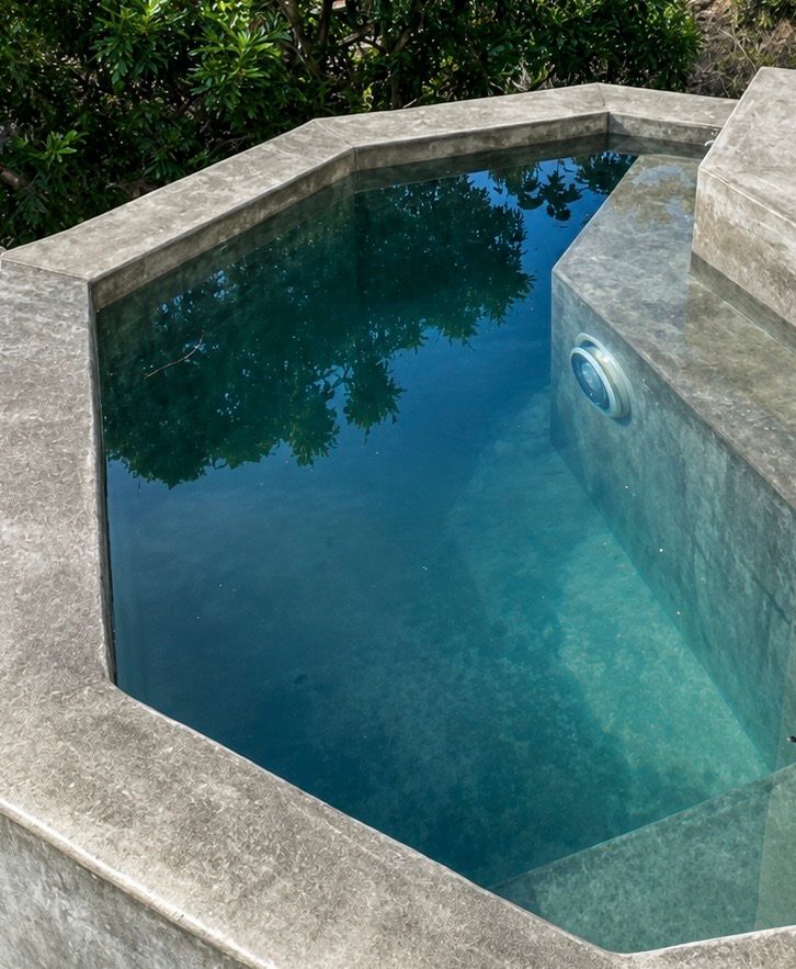 Private stone plunge pool on the garden side, its still water reflecting the surrounding greenery